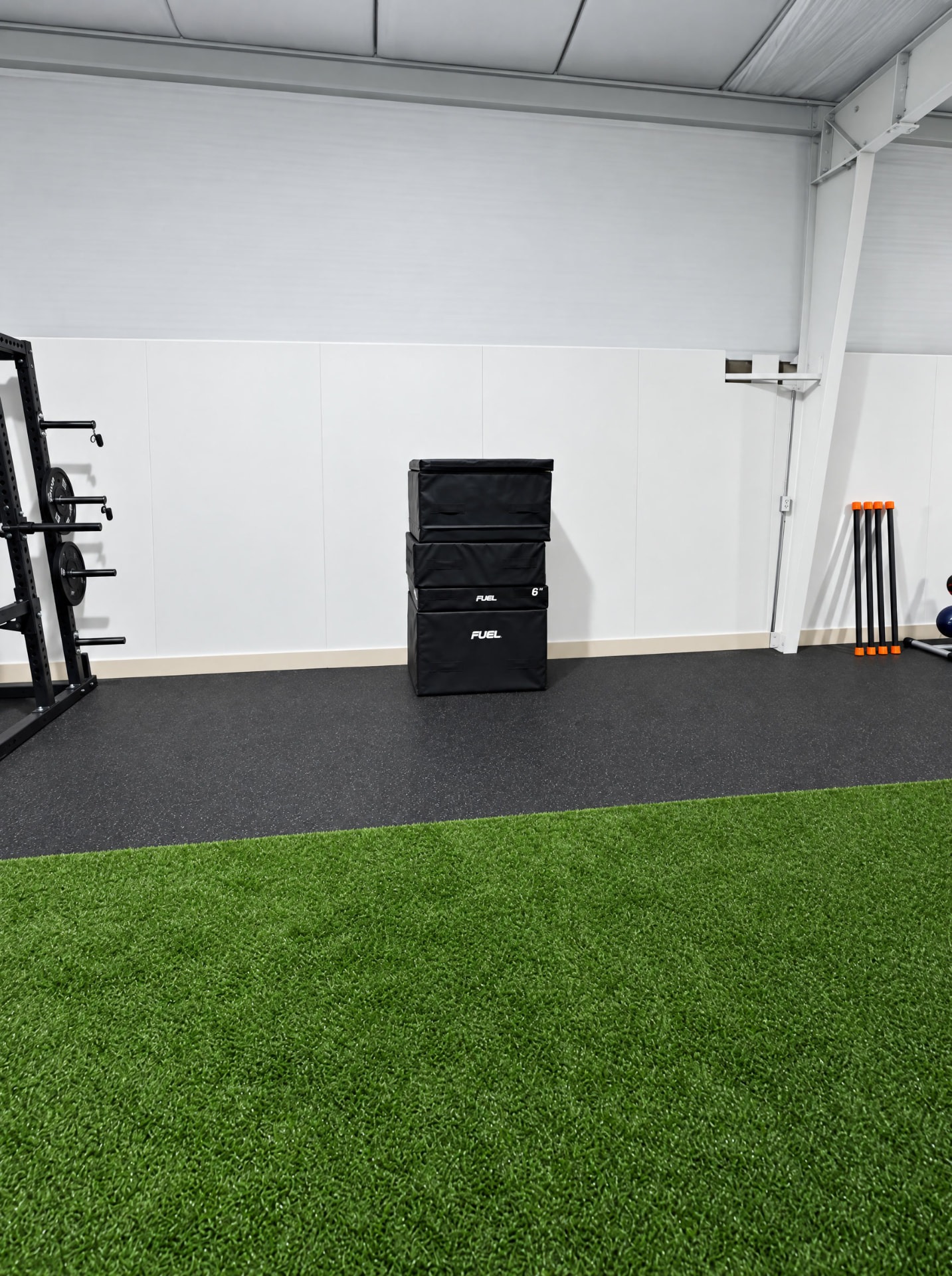 Stacked plyometric training boxes beside THE R's indoor turf