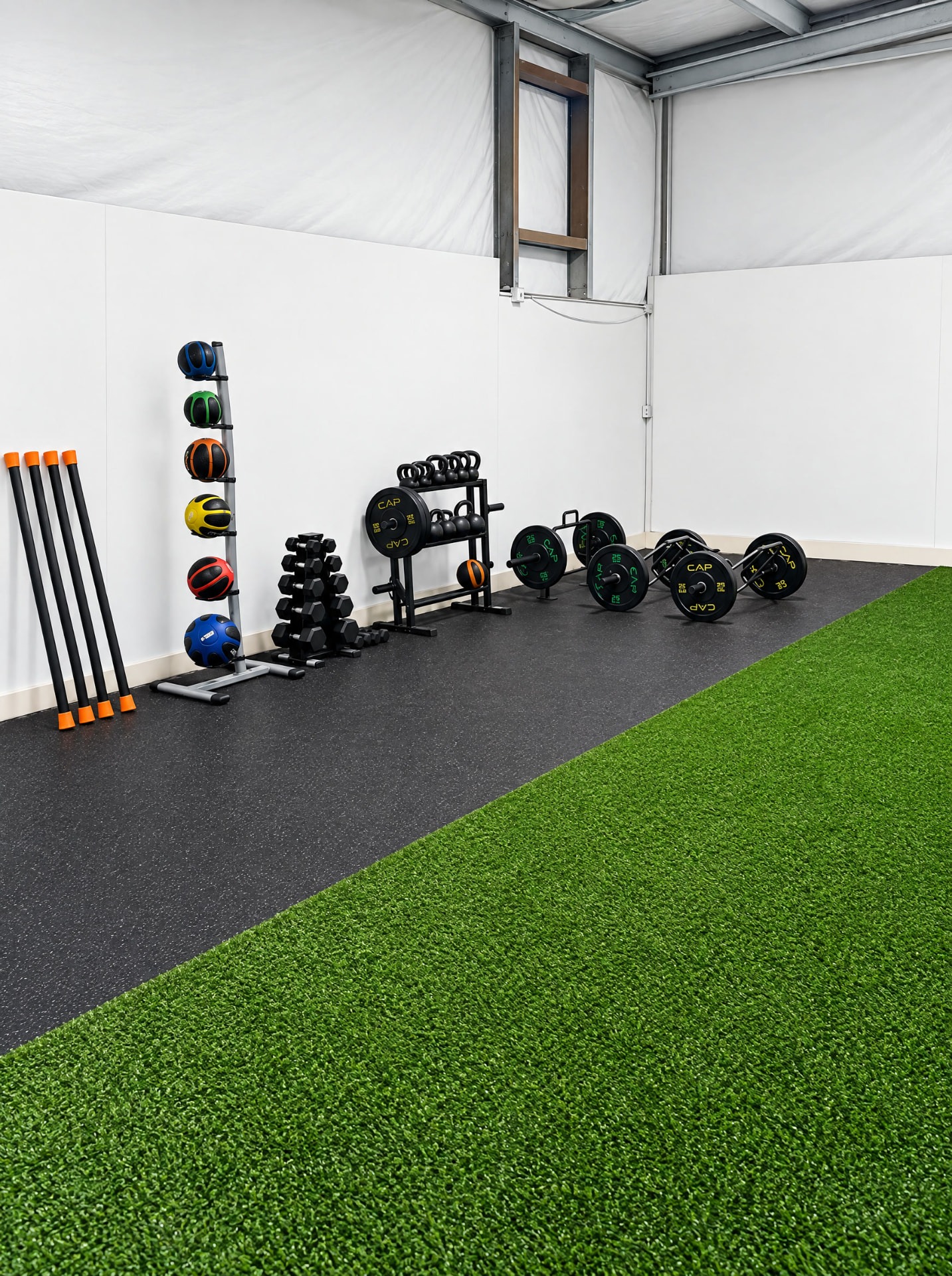 Medicine balls, free weights, and training tools beside THE R turf